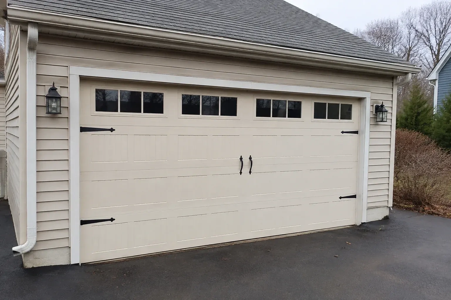 Cream carriage-house-style garage door with dark decorative hardware. — Carriage-House Garage Door Installation, Whitchurch-Stouffville
